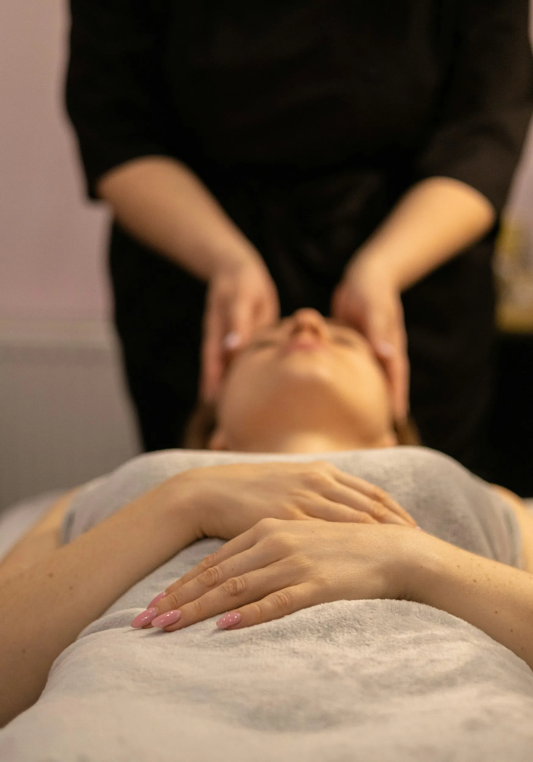 A therapist supporting a patient’s jaw and neck during treatment.